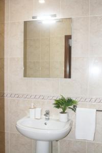 un bagno con lavandino e specchio di Gare Do Sol Free Parking and Smart TV ad Aveiro