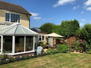 a garden with a conservatory in a yard at Hysett House in Midhurst