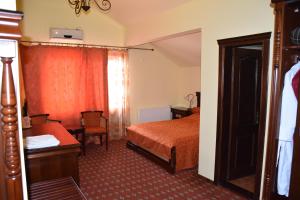 a hotel room with a bed and a chair at Pension Kokett in Cîmpulung