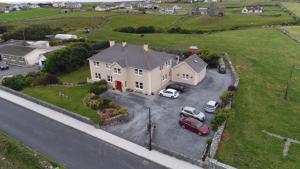 a large house with cars parked in a parking lot at Moloney House in Doolin