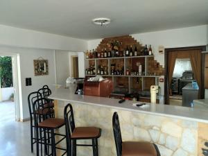 a bar with chairs and a counter in a room at Tholos Rooms in Kavoúsion