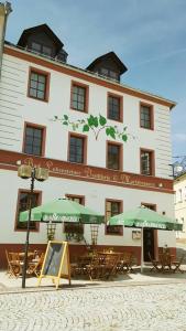 un edificio con tavoli e ombrelloni di fronte ad esso di Hotel Marktbrauerei a Bad Lobenstein