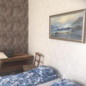 Un dormitorio con una cama y un cuadro en la pared. en Kansakoulu, en Västanfjärd