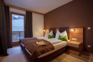 a bedroom with a large bed with a large window at Naturhotel Rainer in Racines