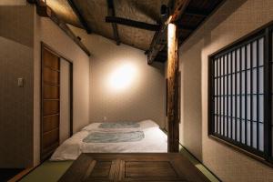 a small room with a bed and a window at Hazuki Kyoto in Kyoto