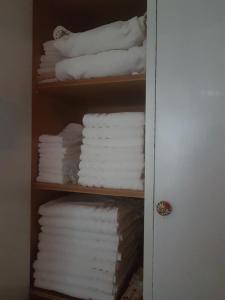 a shelf filled with white towels in a bathroom at Marco's house in Dolianova +57 photos