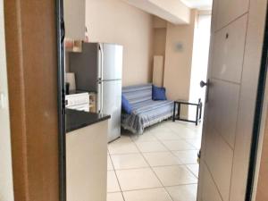 a kitchen with a refrigerator and a couch in a room at Pireaus Port Cosy apartment Wifi AC in Piraeus