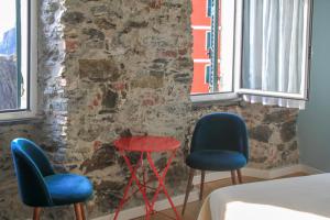 two chairs and a red table in a room at Orto al Mare Room Rental in Riomaggiore