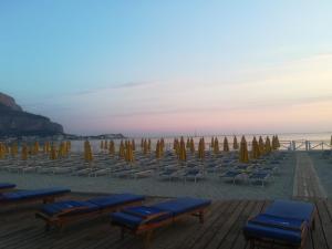 a bunch of chairs and umbrellas on a beach at La stanza di Angi a Mondello in Palermo