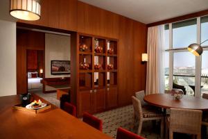 a dining room with a table and a room with a bedroom at Yas Island Rotana Abu Dhabi in Abu Dhabi