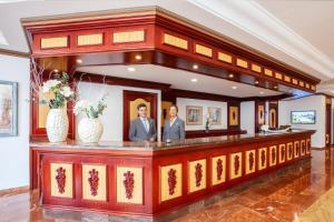 two men standing at a bar in a room at Grupotel Santa Eulària & Spa - Adults Only in Santa Eularia des Riu +44 photos