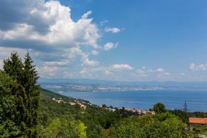 vistas al agua y a una ciudad en una colina en Apartments Melanie, en Opatija