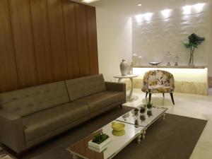 a living room with a couch and a table at Apartamento Residencial Julia in Guarapari