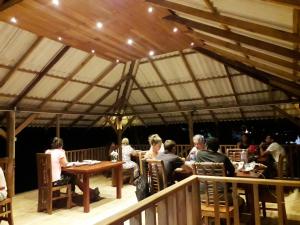 un groupe de personnes assises à des tables dans une tente dans l'établissement Sigiriya Paradise Inn, à Sigirîya