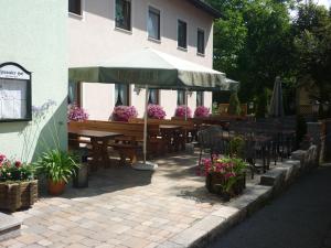 a restaurant with tables and chairs and an umbrella at Zenntaler Hof in Neuhof an der Zenn