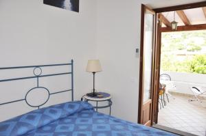una camera con letto blu e balcone di Case Vacanze S. Anna a Città di Lipari
