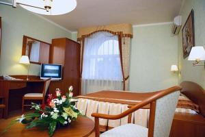 a living room with a table with a vase of flowers at Residence Troya in Samara