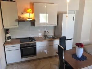 a kitchen with a table and a sink and a refrigerator at Apartment Ante in Šibenik