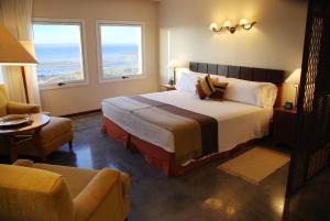 a hotel room with a bed and two windows at Hotel Territorio in Puerto Madryn