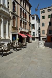 un patio con mesas, sillas y edificios en Residence La Fenice en Venecia