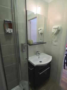 a bathroom with a sink and a shower with a mirror at Bella Vita Rooms in Naples