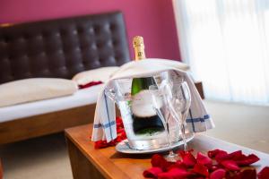 a table with a bottle of wine in a glass container at Swiss Heidi Hotel in Maienfeld