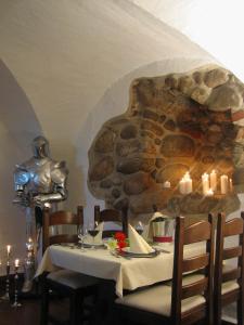 a dining table with candles and a stone wall at Hotel Schloss Spyker in Glowe