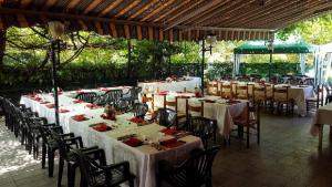 a group of tables and chairs with white tablecloths at Appartamento Nerio in Muggia