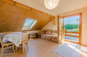 ein Wohnzimmer mit einem Tisch und einem Sofa in der Unterkunft Domek na Górce in Sorkwity