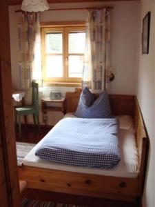 Bergpension Zinting في بريكسن ام تاله: غرفة نوم عليها سرير ومخدات زرقاء