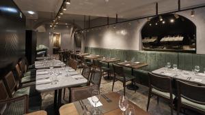 a restaurant with tables and chairs with wine glasses at My Story Hotel Tejo in Lisbon