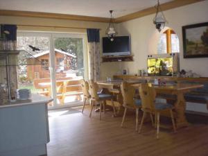 uma sala de jantar com uma mesa e cadeiras e uma televisão em Pension Haus am Heubach em Bad Staffelstein