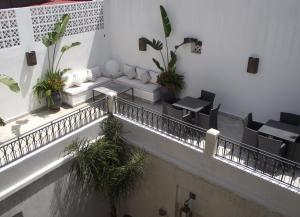 a balcony with tables and chairs in a building at Riad Dar Zen in Rabat