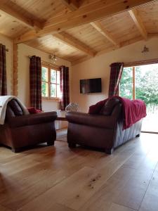 a living room with two couches and a tv at West Pool Cabin in Lincoln