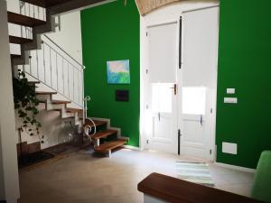 Habitación verde con escaleras y pared verde en Sicily The Well Apartments, en Milazzo