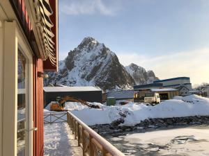 a view of a snow covered mountain from a balcony at Nora's Waterfront Cabin in Svolvær