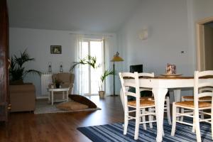 uma sala de estar com uma mesa branca e cadeiras em B&B Mario & Mario em Trezzo Tinella