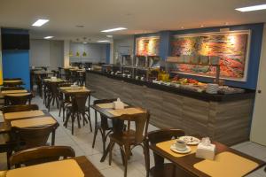 a restaurant with tables and chairs and a bar at EXPRESSO R1 HOTEL in Maceió