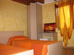 a bedroom with two beds with orange and orange sheets at B&B Melius in Migliuso