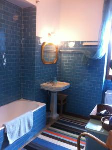 niebieska łazienka z wanną i umywalką w obiekcie Sweet Home w mieście Faggeto Lario 