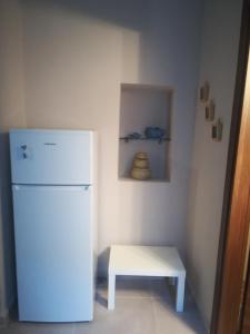 uma pequena cozinha com um frigorífico branco e uma mesa em Port's little gem em Pireu