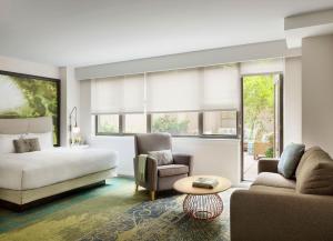 een slaapkamer met een bed, een bank en een tafel bij The Gardens Sonesta ES Suites New York in New York