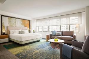 Un dormitorio con una cama, un sofá y una mesa. en The Gardens Sonesta ES Suites New York, en Nueva York