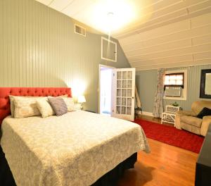 a bedroom with a large bed with a red headboard at Historic Apartment in the Heart of Christiansted in Christiansted