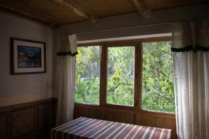a bedroom with a window and a bed and a table at Eco Lodge Los Perales-Urubamba in Urubamba