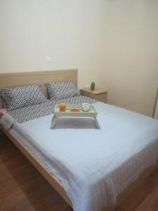 a white bed with a tray on top of it at Pireaus charming sparkle in Piraeus