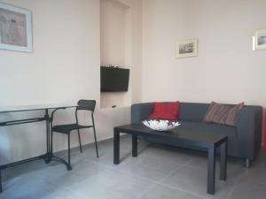a living room with a couch and a table at Pireaus charming sparkle in Piraeus