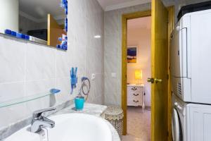 a bathroom with a sink and a refrigerator at ApartUP Saplaya Harbour in Alboraya