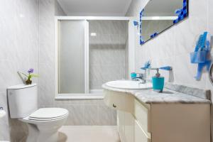 a white bathroom with a toilet and a sink at ApartUP Saplaya Harbour in Alboraya