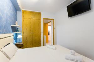a bedroom with a bed and a tv on the wall at ApartUP Saplaya Harbour in Alboraya